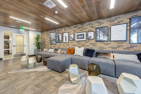 a living room with couches and chairs and a wall of pictures